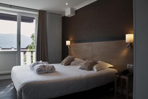 Hôtel Beau Rivage tesisinde bir odada yatak veya yataklar