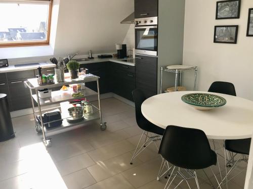 a kitchen with a table and chairs in a kitchen at Appartement Cousteau - Terras, Zeezicht, Marina in Ostend