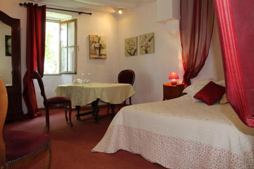 um quarto com uma cama, uma mesa e uma janela em La Closerie em Saint-Philbert-du-Peuple