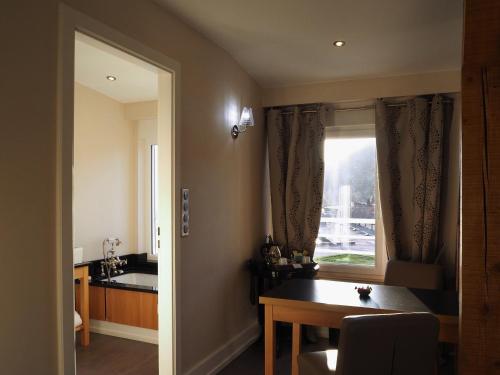 a dining room with a table and a window at Hôtel Beau Rivage in Gérardmer