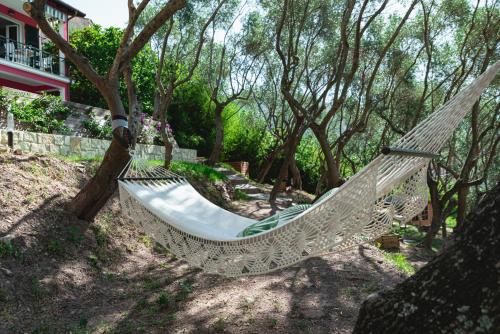 a hammock in a yard with trees and a house at Cà del Mago Pool garden & spa, only adults in Lerici