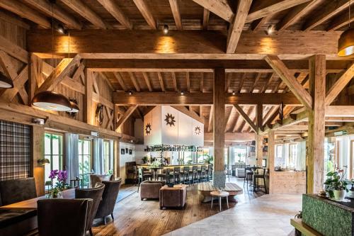 a large room with wooden ceilings and tables and chairs at Hotel & Chalets Edelweiss in Madonna