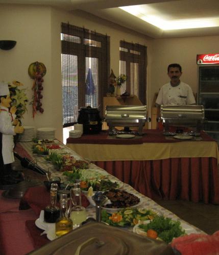a man standing in a restaurant with a table full of food at Ataer Hotel in Antalya
