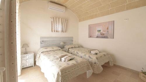 um quarto com duas camas num quarto em WHITE STONE HOUSE 6&1, Emma Villas em Ostuni