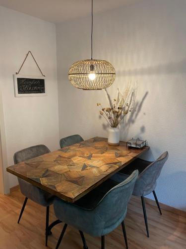 a dining room table with chairs and aendant light at Fehmarn Oase in Petersdorf auf Fehmarn