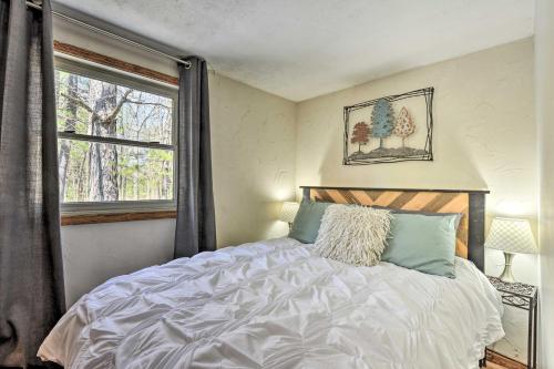 a bedroom with a large bed and a window at Cozy Cabin with Sunroom and Cacapon River Access! in Capon Bridge