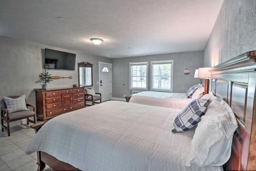 a bedroom with two beds and a dresser and a television at Trout Fishing Retreat on White River with Patio in Lakeview