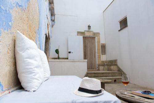 een bed met een hoed en een glas wijn bij La Casa e la Corte in Salve