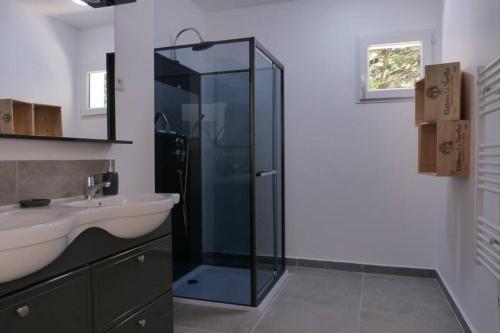 La salle de bains est pourvue d'une douche en verre et d'un lavabo. dans l'établissement Gîte entièrement rénové sur le thème de la mer., à Carpentras