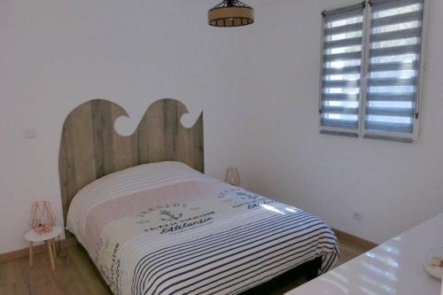 - une chambre avec un lit et une tête de lit en bois dans l'établissement Gîte entièrement rénové sur le thème de la mer., à Carpentras