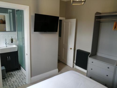 um quarto com uma cama, um lavatório e uma televisão em North Ings em Robin Hood's Bay