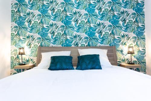 une chambre avec un lit avec deux oreillers bleus dans l'établissement Suite Tropical Disneyland Paris - Jardin privé !, à Montévrain