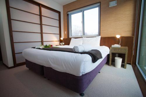 倶知安町にあるトショカンの大きな窓のある部屋にある大きなベッド