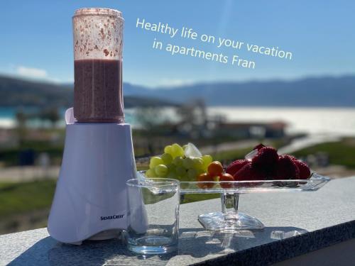 a blender and a plate of fruit on a table at Apartments Fran in Baška