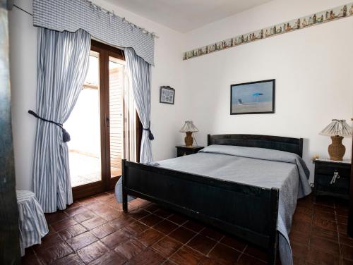 a bedroom with a bed and a large window at Villa Sciacca Lumia in Sciacca