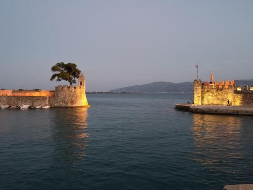 a castle in the middle of a body of water at Ecco Apartments I in Nafpaktos
