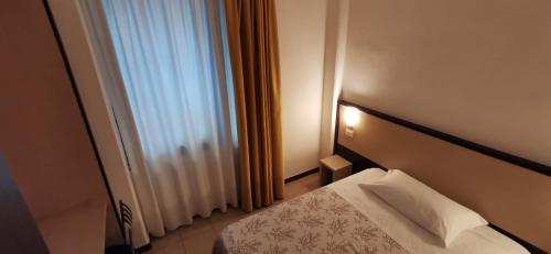 a hotel room with a bed and a window at Hotel Rondine in Marinella di Sarzana