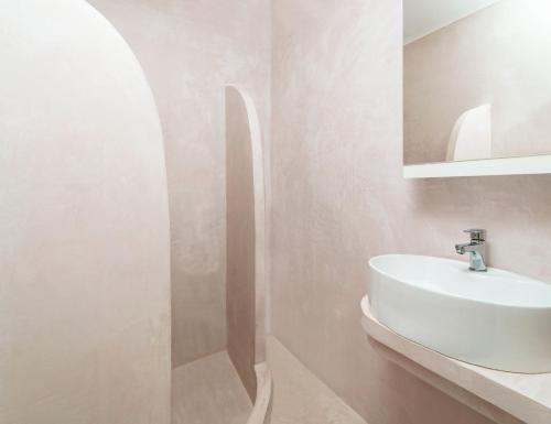 uma casa de banho com um lavatório branco e um espelho. em Adani Hotel em Tsoukaladhes