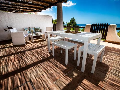 einen weißen Tisch und Stühle auf einer Terrasse mit Meerblick in der Unterkunft Villa Sciacca Lumia in Sciacca