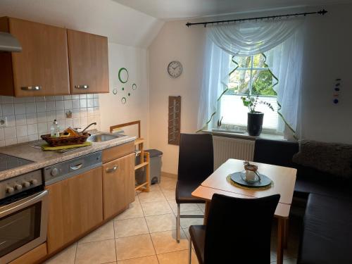 a kitchen with a table and a sink and a window at Pension Villa Frohsinn Sellin auf Rügen in Ostseebad Sellin