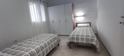 a bedroom with two beds and a window at DOLCE CASA Baïa Sant'Anna - Budoni in Budoni
