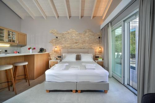a bedroom with a large bed and a kitchen at Paxos Luxury Living Junior Suites in Gaios