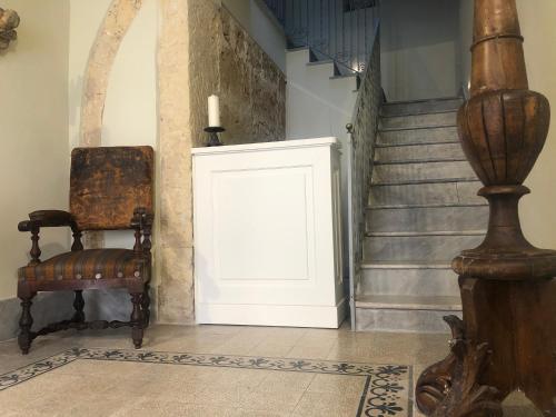 a room with a door and a chair and stairs at Casa Modica - Luxury rooms in Noto