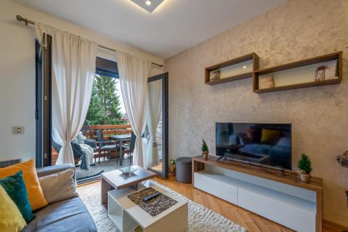 uma sala de estar com um sofá e uma televisão em Centar M LUX Zlatibor em Zlatibor