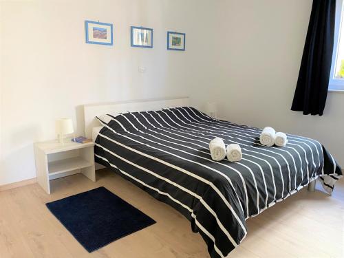 sypialnia z łóżkiem z czarno-białą kołdrą o paskach w obiekcie Apartment Punta Premantura E with garden w mieście Premantura