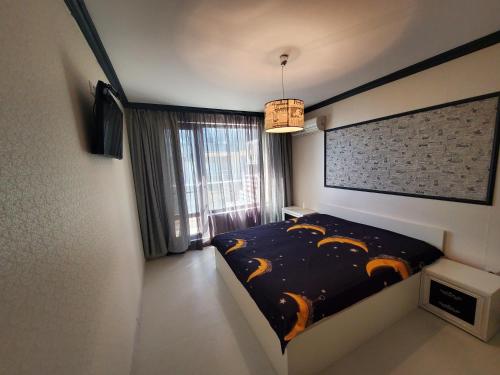 1 dormitorio con cama y ventana grande en Апартамент Анели, en Pomorie