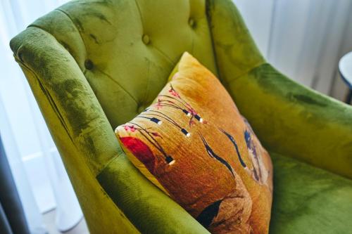 a pillow sitting on top of a green chair at Boutiquehotel Liebesglück - adults only in Winterberg