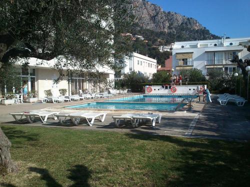 una piscina con mesas y sillas junto a un edificio en Apartament L'Estartit - Costa Brava, en Torroella de Montgrí