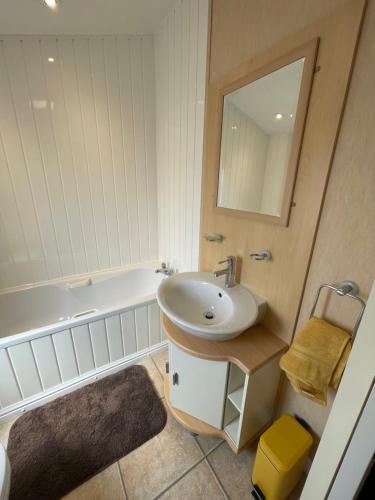 a bathroom with a sink and a tub and a mirror at Torrey Pines - 2 bedroom hot tub lodge with free golf, NO BUGGY in Swarland