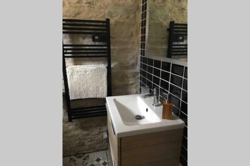 La salle de bains est pourvue d'un lavabo et d'un miroir. dans l'établissement Maison proche centre-ville, à Dijon