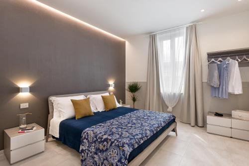 Schlafzimmer mit einem großen Bett mit blauer und weißer Bettwäsche in der Unterkunft Oltremare in Follonica