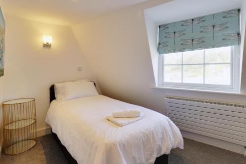 a small bedroom with a bed and a window at Master accommodation suite 9 single room With roof top views in Hastings