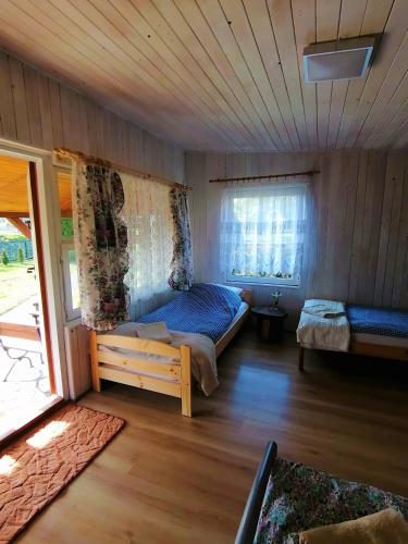 a bedroom with a bed in a room with a window at Domek Stary Bar in Piecki
