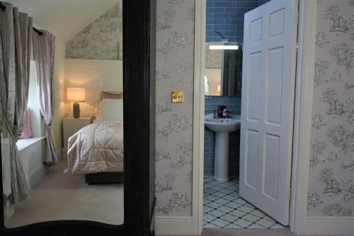 a bathroom with a bedroom with a bed and a sink at Bedford House & Hall in Balbriggan