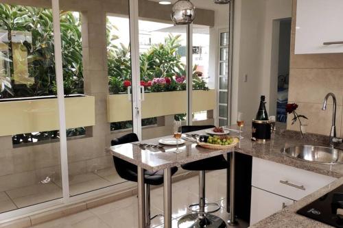 a kitchen with a sink and a counter with glasses of wine at Departamento María Félix - Dpto de 1 Habitación con Bella terraza común - Zona tranquila en CDMX in Mexico City