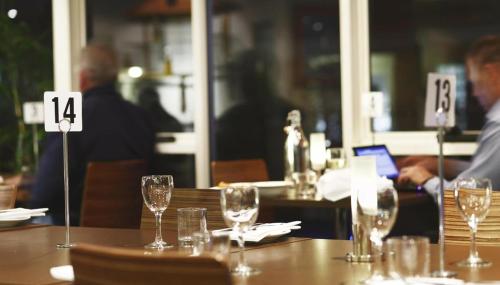a table in a restaurant with wine glasses on it at ibis Styles Canberra in Canberra
