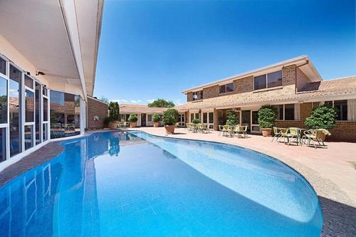 una gran piscina frente a una casa en ibis Styles Canberra, en Canberra