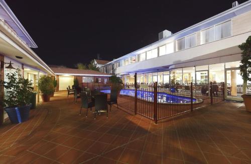 a building with a fence in front of it at night at ibis Styles Canberra in Canberra