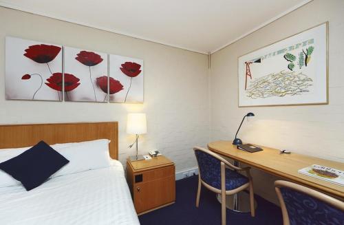 a hotel room with a bed and a desk and a bed and a desk at ibis Styles Canberra in Canberra
