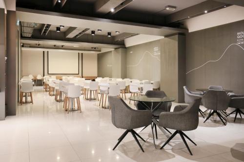 a conference room with tables and chairs and a projection screen at Dandy Hotel-Daan Park Branch in Taipei