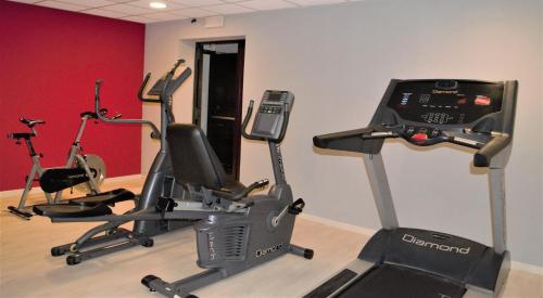 a gym with three exercise bikes and a treadmill at Hotel Fiera Di Brescia in Brescia