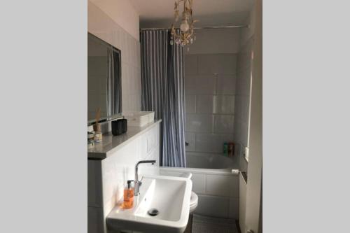 uma casa de banho com um lavatório e uma banheira em 5-Zi. Wohnung in Bahnhofsnähe - 24/7 self-check-in em Borstel