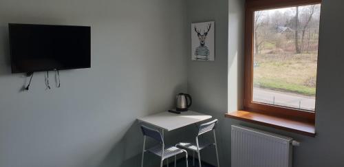 a room with a desk and a television and a window at Willa Czajki in Oświęcim