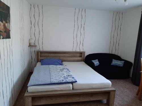 a small bedroom with a bed and a chair at Goode Wind in Norden