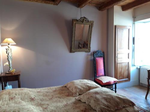 una camera con letto, specchio e sedia di Maison Lépie a Beurlay