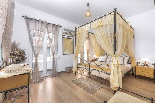 a bedroom with a canopy bed and curtains at Dennis City Center Elegant Apartment (2) in Zakynthos Town